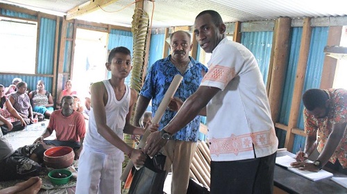 Rt-Kini-Sovea-and-Mr-Jone-Jiuta-from-the-Ministry-of-Women-Children-Poverty-Alleviation-handing-over-school-stationeries-to-the-students-at-the-Nanuku-Settlement-in-Vatuwaqa.jpg